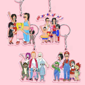 May include: Four acrylic keychains featuring cartoon characters. One keychain has the text "Happy 4th of July!". The keychains depict families and characters in various outfits, with a pink background and silver key rings.