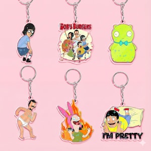 May include: Keychains featuring characters from the animated TV show Bob's Burgers. The keychains include images of Tina Belcher, the Belcher family, a green character with a blue bow tie, Bob Belcher, Louise Belcher in flames, and Gene Belcher with the text "I'M PRETTY".