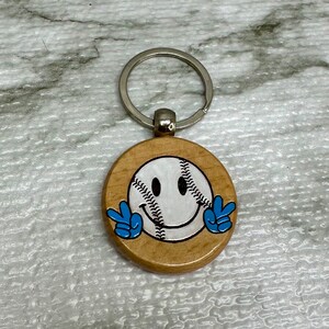 Lustiger Keychain mit Haltung.  Baseball Schlüsselanhänger aus Holz.