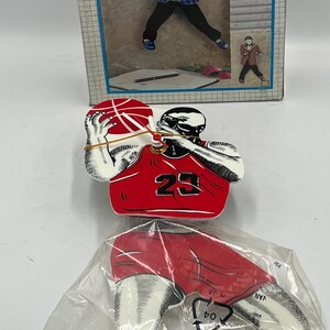May include: A pendulum clock kit featuring a basketball player design. The clock's packaging displays the words "PENDULUM CLOCK" at the top. The kit includes a basketball player figure and legs in a plastic bag.