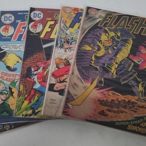 Könnte beinhalten: Eine Sammlung von Vintage-Comics mit Flash. Die Cover zeigen farbenfrohe Illustrationen des Superhelden in Aktion, mit Texten wie "The Flash" und "Super-Speed Showdown". Die Comics sind in Schutzhüllen.