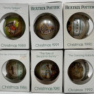 May include: Six Beatrix Potter Christmas ornaments in white boxes. The ornaments feature illustrations from stories like Timmy Tiptoes, The Tale of the Flopsy Bunnies, The Tale of Benjamin Bunny, and The Dancing Rabbits, with dates ranging from 1981 to 1992.