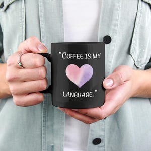 May include: Black coffee mug with a white heart design and the text "Coffee is my language."