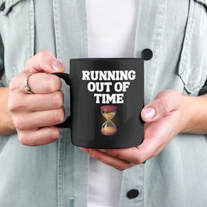 May include: Black coffee mug with a white hourglass graphic and the text "RUNNING OUT OF TIME".