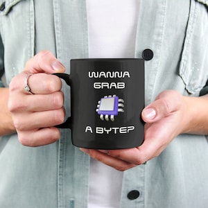 May include: Black coffee mug with a white graphic of a computer chip and the text "Wanna grab a byte?"