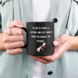 May include: Black coffee mug with white text that reads "I'd like to thank all caffeine, and last-minute panic for making this possible." A red and white scroll is pictured below the text.