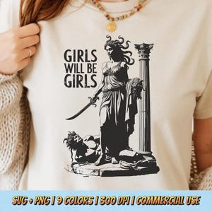 Può includere: Una maglietta color crema con una grafica nera di una figura femminile classica che tiene una spada, con la scritta "GIRLS WILL BE GIRLS". Il disegno include una figura caduta e una colonna. La parte inferiore della maglietta riporta la scritta "SVG + PNG | 9 COLORS | 300 DPI | COMMERCIAL USE".