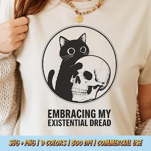 May include: A cream-colored t-shirt features a black cat embracing a skull within a black circle. The text "EMBRACING MY EXISTENTIAL DREAD" is below the graphic. The bottom of the image includes text about the design's format and commercial use.