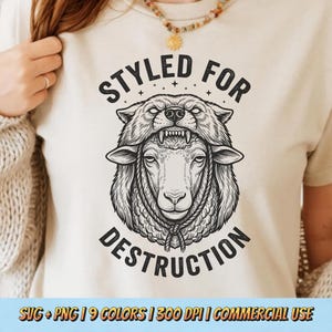 以下が含まれることがあります： クリーム色のTシャツ。黒と白のイラストで、オオカミの頭飾りをかぶった羊が描かれています。「STYLED FOR DESTRUCTION」の文字が画像の上部と下部にアーチ状に配置されています。画像の下部にはテキスト「SVG + PNG | 9 COLORS | 300 DPI | COMMERCIAL USE」が含まれています。