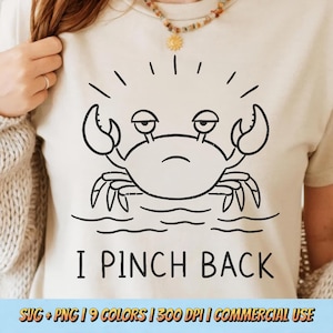 May include: Beige t-shirt featuring a black cartoon crab with a grumpy expression, set against a water line. The text "I PINCH BACK" is below the crab. The bottom of the image includes text about SVG and PNG formats, color options, and commercial use.