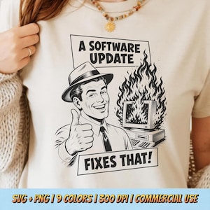 May include: A cream-colored t-shirt featuring a black graphic of a smiling person in a fedora giving a thumbs up next to a computer monitor engulfed in flames. The text reads A SOFTWARE UPDATE and FIXES THAT! in bold black capital letters.