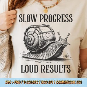 Puede incluir: Camiseta beige con el texto "SLOW PROGRESS LOUD RESULTS". El diseño es una ilustración en blanco y negro de un caracol con un tambor. La camiseta también incluye el texto "SVG + PNG | 9 COLORS | 300 DPI | COMMERCIAL USE".