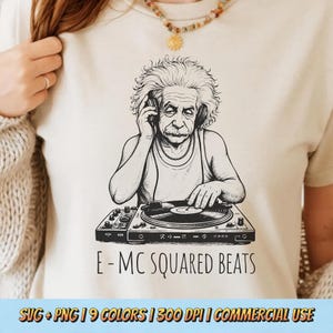 May include: Cream-colored t-shirt featuring a black and white illustration of Albert Einstein as a DJ, wearing headphones and operating a turntable. The text "E-MC SQUARED BEATS" is below the image. The shirt also has the text "SVG + PNG | 9 COLORS | 300 DPI | COMMERCIAL USE".
