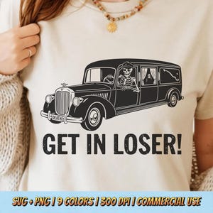 May include: Beige t-shirt featuring a black graphic of a hearse driven by a skeleton. The text "GET IN LOSER!" is below the hearse. The word "DEATH" is on the front of the hearse. The shirt is a casual wear item.