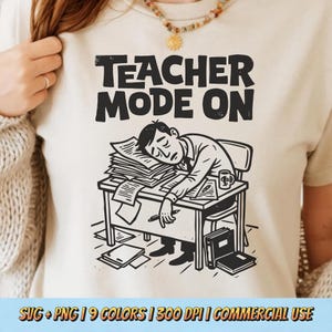 Może przedstawiać: Beżowa koszulka z czarną grafiką z napisem "TEACHER MODE ON". Grafika przedstawia osobę śpiącą przy biurku zawalonym papierami. Na biurku znajdują się również kubek i książki. Tekst na dole obrazu.
