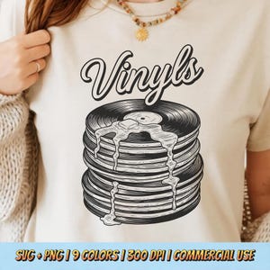 Puede incluir: Camiseta color crema con un diseño de una pila de discos de vinilo con mantequilla derretida y la palabra "Vinyls" en fuente cursiva. La parte inferior de la camiseta tiene el texto "SVG + PNG | 9 COLORS | 300 DPI | COMMERCIAL USE".