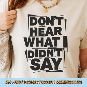 May include: A cream-colored t-shirt with the bold text "DON'T HEAR WHAT I DIDN'T SAY" in black. The design is a modern, blocky font. The bottom of the image includes text about the design being available in SVG and PNG formats, 9 colors, 300 DPI, and for commercial use.