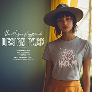 May include: A woman wearing a gray t-shirt with the text "HARD FOUGHT HALLELUJAH" in a stylized font. She is also wearing a wide-brimmed hat and a mustard-colored skirt. The image also includes text that says "the artisan playground DESIGN PACK".
