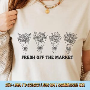 May include: Beige t-shirt featuring a black line drawing of four bouquets of flowers. The text "FRESH OFF THE MARKET" is below the bouquets. The bottom of the image has text that reads "SVG + PNG | 9 COLORS | 300 DPI | COMMERCIAL USE."