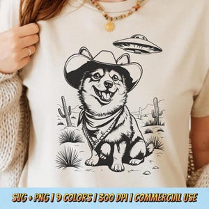 May include: Black and white illustration of a dog wearing a cowboy hat and bandana, with a UFO in the background. The dog is standing in a desert landscape with cacti.