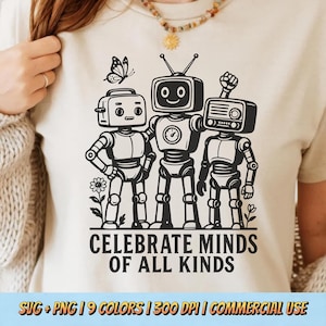 Puede incluir: Camiseta beige con un gráfico en blanco y negro de tres robots con diferentes diseños de cabeza. También se incluye una mariposa y flores en el diseño. El texto "CELEBRATE MINDS OF ALL KINDS" está impreso debajo.