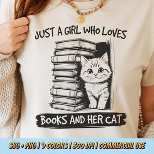 Może przedstawiać: Beżowa koszulka z czarno-białą grafiką przedstawiającą stos książek i kota. Tekst brzmi: "JUST A GIRL WHO LOVES BOOKS AND HER CAT".