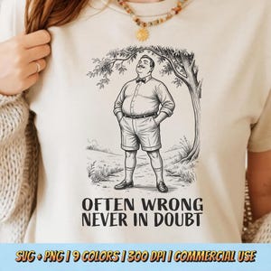 May include: A cream-coloured t-shirt featuring a black line-art illustration of a man in a button-down shirt and shorts standing under a tree. Below the illustration, the text reads: OFTEN WRONG NEVER IN DOUBT. The shirt has a crew neckline.