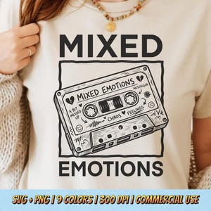May include: Beige t-shirt with a black graphic of a cassette tape that reads "Mixed Emotions." The tape design includes the words "Chaos," "Feelings," and "Nostalgia." The shirt also has the words "Mixed Emotions" and "Emotions" printed on it.