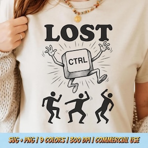 May include: Beige t-shirt with a black graphic of a dancing CTRL key with the word "LOST" above it. Three black silhouettes dance below the key. The shirt also has text at the bottom.