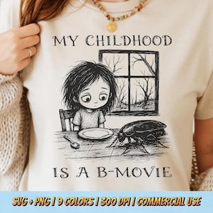 May include: A cream-colored t-shirt featuring a black ink-style illustration of a child sitting at a table with a large cockroach. The text reads MY CHILDHOOD IS A B-MOVIE. The graphic includes a window with bare trees and a spoon on the table.