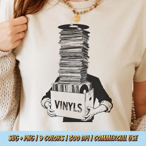Puede incluir: Camiseta beige con un gráfico en blanco y negro de una persona que lleva una caja con la etiqueta "VINYLS" llena de discos, con una pila de discos encima. La imagen incluye texto en la parte inferior: SVG + PNG | 9 COLORS | 300 DPI | USO COMERCIAL.