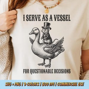 May include: Cream-coloured t-shirt featuring a black and white illustration of a duck with a mouse in a top hat and suit. The text says "I SERVE AS A VESSEL FOR QUESTIONABLE DECISIONS".