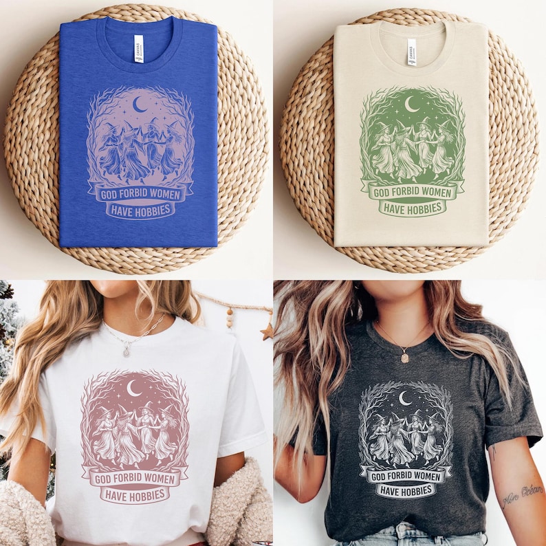 May include: Four t-shirts in blue, beige, white, and charcoal gray, each featuring a graphic of dancing figures under a crescent moon and the text "GOD FORBID WOMEN HAVE HOBBIES". The shirts are folded on woven mats.