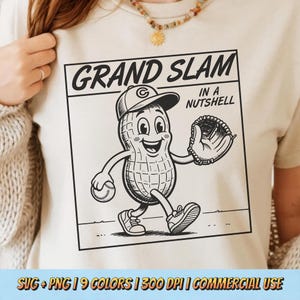 May include: A cream-colored t-shirt featuring a black graphic of a cartoon peanut wearing a baseball cap and glove, holding a baseball. The text reads GRAND SLAM IN A NUTSHELL. The design is enclosed in a square frame with a clean, bold line art style.