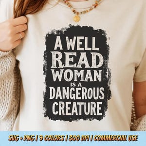 Könnte beinhalten: Cremefarbenes T-Shirt mit einem schwarzen rechteckigen Grafikdesign. Der Aufdruck zeigt den weißen Text: "A WELL READ WOMAN IS A DANGEROUS CREATURE". Der untere Teil des Shirts hat den Text "SVG + PNG | 9 COLORS | 300 DPI | COMMERCIAL USE".