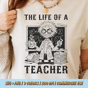 May include: Beige t-shirt with a black and white graphic of a cartoon scientist holding a mug and a pointer, standing in front of a chalkboard. The text "THE LIFE OF A TEACHER" is printed above and below the graphic.