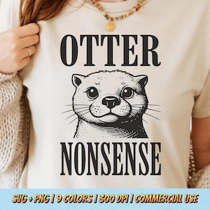 May include: Beige t-shirt featuring a black illustration of an otter with the words "OTTER" above and "NONSENSE" below. The otter has a cute, cartoonish design. The shirt also includes text at the bottom.