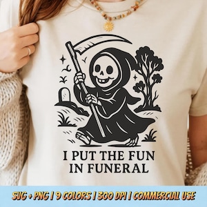 May include: Beige t-shirt featuring a black graphic of a cartoon Grim Reaper with a scythe, walking on grass. The text "I PUT THE FUN IN FUNERAL" is below the graphic. The shirt is a light neutral color.