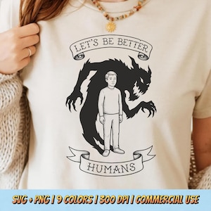 May include: Beige t-shirt with a graphic design featuring a person standing in front of a dark monster silhouette. The text "LET'S BE BETTER" is above the monster, and "HUMANS" is below. The shirt is a neutral color.