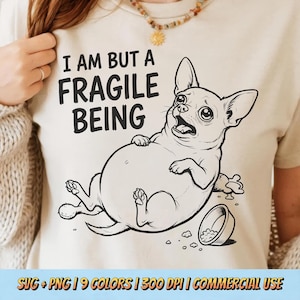 May include: A cream-colored t-shirt featuring a distressed illustration of a chihuahua with a surprised expression. The text "I AM BUT A FRAGILE BEING" is printed above the dog. The design includes a spilled food bowl and scattered kibble.