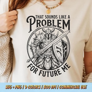 May include: Beige t-shirt with a black and white graphic of an armored knight holding a sword and shield. Text reads "THAT SOUNDS LIKE A PROBLEM FOR FUTURE ME". The shirt is a neutral color.
