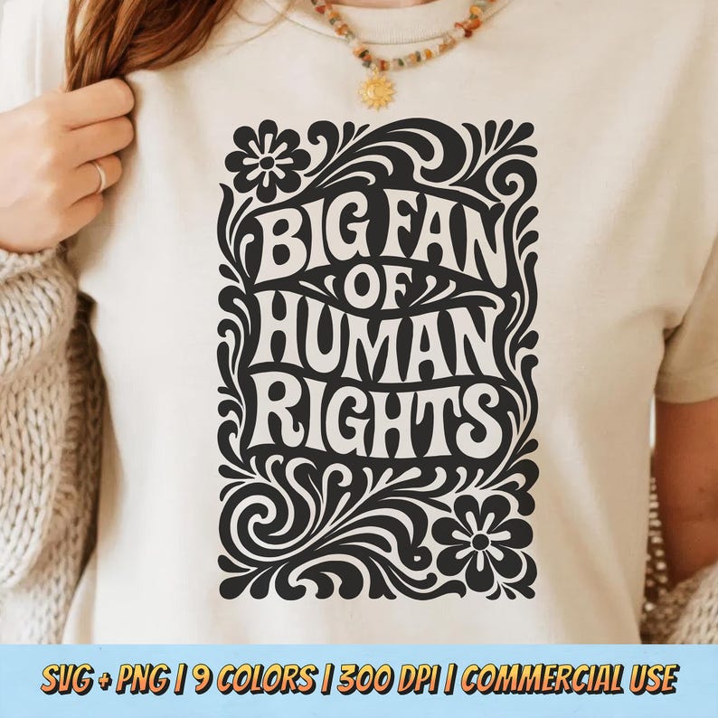 Puede incluir: Camiseta color crema con un gr&aacute;fico negro que dice "BIG FAN OF HUMAN RIGHTS" en una fuente decorativa. El dise&ntilde;o est&aacute; enmarcado por elementos florales y arremolinados. La camiseta es de color neutro y tiene mangas cortas.