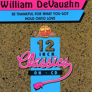 Può includere: Copertina dell'album "12 Inch Classics" di William DeVaughn. Il design presenta il nome dell'artista in rosa, con i titoli delle canzoni in blu. Un rettangolo blu mostra "12 INCH Classics ON CD" in rosa e bianco, con una grafica rosa.