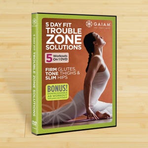 May include: A DVD case for the "5 Day Fit Trouble Zone Solutions" workout program. The cover features a woman in a yoga pose, with text highlighting the program's focus on firming glutes, toning thighs, and slimming hips. Includes a bonus downloadable ab workout.