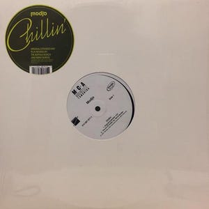 Peut inclure: Un disque vinyle blanc avec deux étiquettes circulaires. L'étiquette supérieure est noire avec le mot "Chillin" en écriture jaune. L'étiquette inférieure est blanche avec le texte "Modjo" et "Side 1".