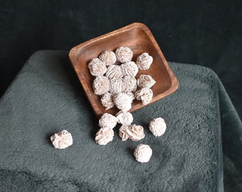 May include: A wooden bowl filled with white rose quartz crystals, with additional crystals scattered on a gray surface.