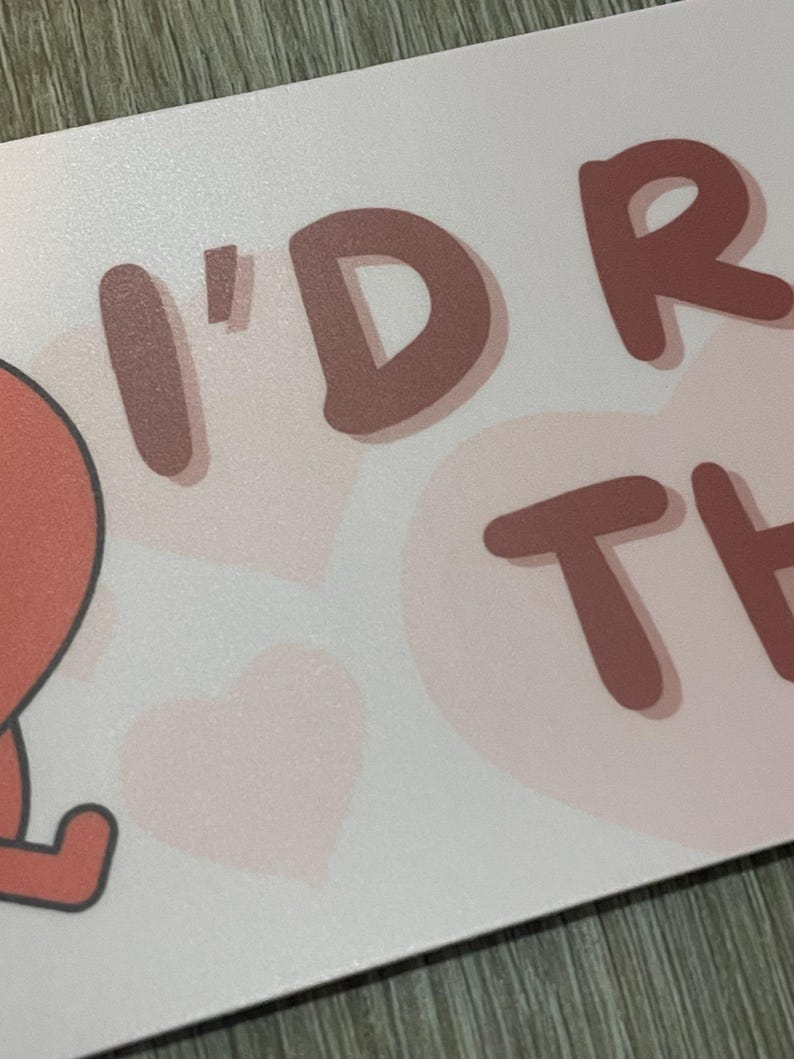 May include: A light pink card with the words "I'D RATHER" in a brown, playful font. The background features light pink hearts. The card has a matte finish.