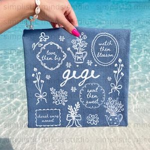 Embroidered blue towel with "Gigi" and floral designs.