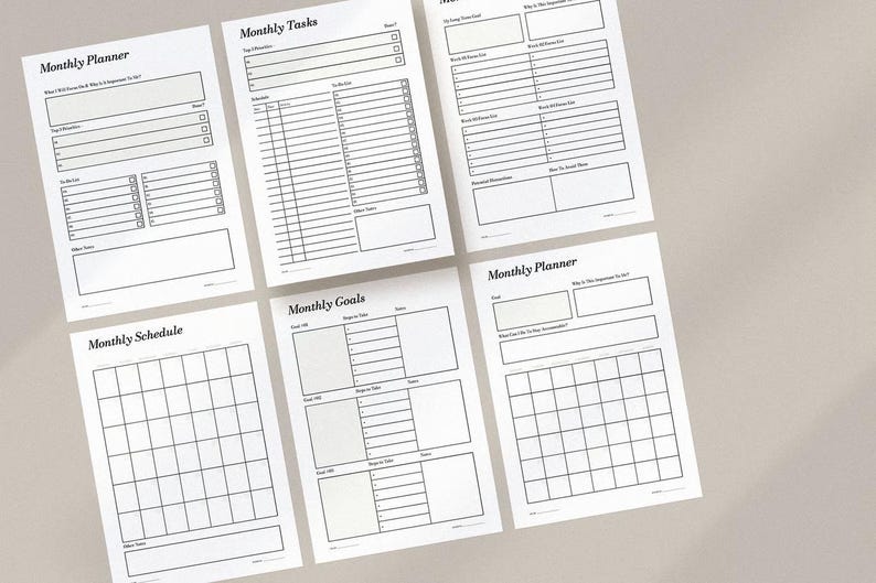 May include: A collection of white paper sheets with black printed text, featuring layouts for monthly planning. The sheets include sections for tasks, goals, and schedules. The text includes the words "Monthly Planner", "Monthly Tasks", "Monthly Goals", and "Monthly Schedule".