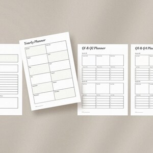 May include: Four white paper planner sheets with black text are arranged on a neutral background. The sheets include "Yearly Goals", "Yearly Planner", "Q1 & Q2 Planner", and "Q3 & Q4 Planner". The "Yearly Planner" sheet has a calendar layout.